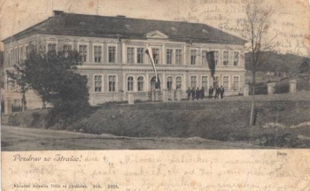 Dobová pohlednice z počátku 20. století zobrazuje původní členitou fasádu školy.